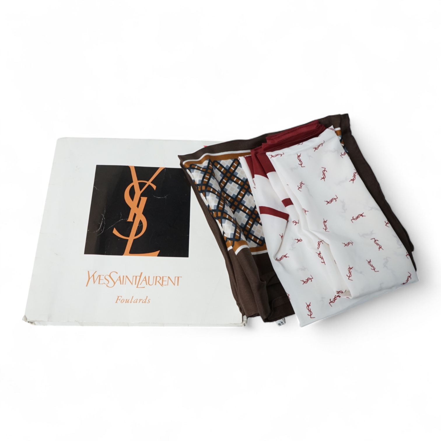 Two Yves Saint Laurent silk scarves comprising a monogrammed example and a patterned brown example with Foulards folding case
